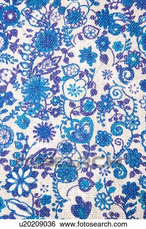 Stock Photograph - Close-up of woven vintage fabric with blue flowers and designs printed on cotton. Fotosearch