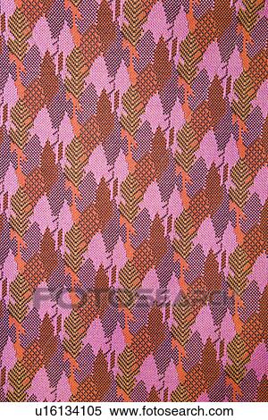 Stock Photography - Close-up of woven vintage fabric with purple and pink repetitive designs. Fotosearch