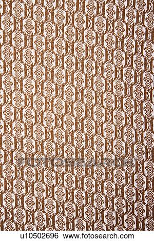 Stock Photograph - Woven vintage fabric with brown repetitive designs. Fotosearch