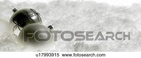 Stock Photography - Two white Christmas baubles on snow. Fotosearch