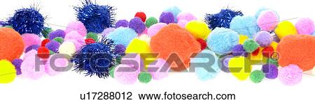 Stock Image - Various assorted colorful pom poms . Fotosearch