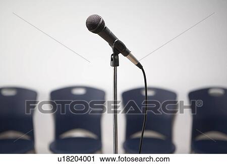 A microphone stand with chairs in the background. View Large Photo Image Stock Image - A microphone stand with chairs in the background.. Fotosearch