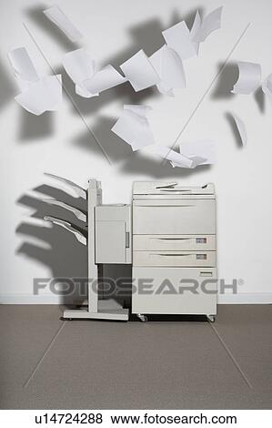 A photocopier against a white wall with paper flying out. View Large Photo Image Stock Photo - A photocopier against a white wall with paper flying out.. Fotosearch