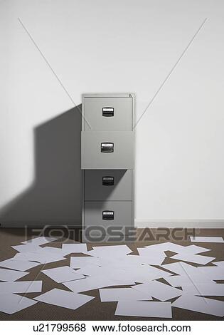 Stock Photo - Filing cabinet against wall with papers strewn about.. Fotosearch