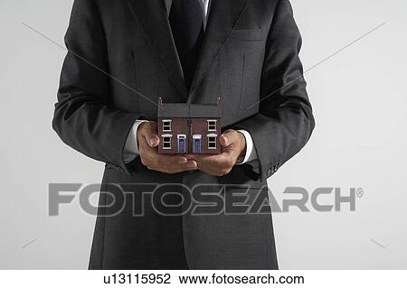 Man holding a model of a red brick house. View Large Photo Image Stock Image - Man holding a model of a red brick house.. Fotosearch