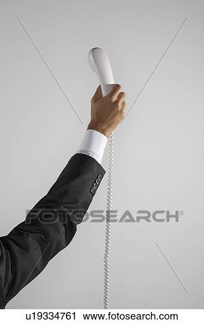 Man's arm holding up a telephone in the air. View Large Photo Image Stock Image - Man's arm holding up a telephone in the air.. Fotosearch