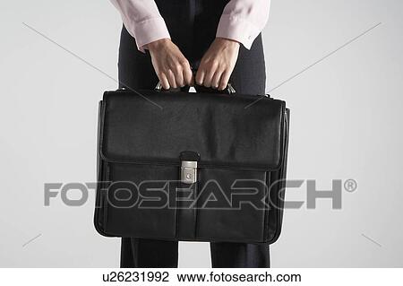 Woman holding a black brief case against her. View Large Photo Image Stock Image - Woman holding a black brief case against her.. Fotosearch
