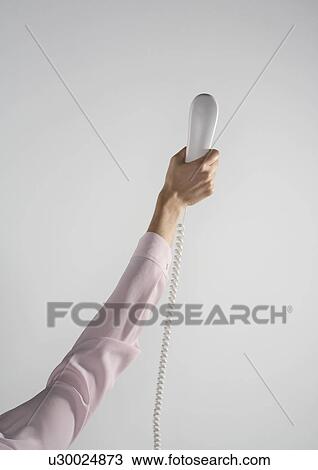 Woman's arm holding up a white telephone in the air. View Large Photo Image Stock Image - Woman's arm holding up a white telephone in the air.. Fotosearch