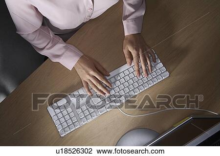 Stock Image - Woman's hands typing on a computers keyboard.. Fotosearch