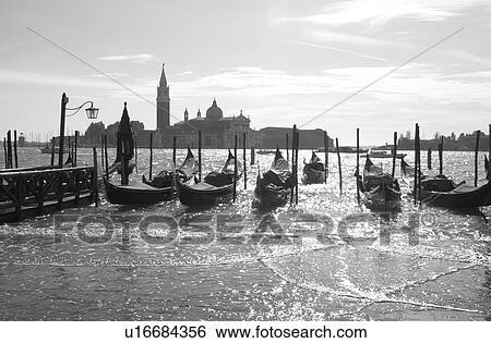 Stock Photograph - Array of gondolas docked at a canal in Venice, Italy. Fotosearch