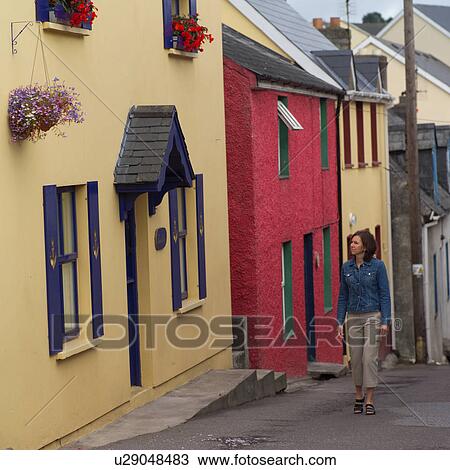 Woman walking down street View Large Photo Image Stock Image - Woman walking down street. Fotosearch