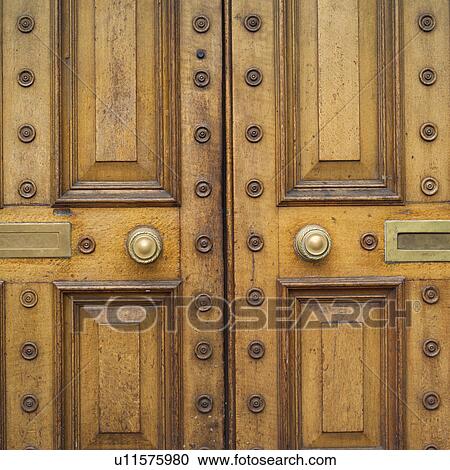 Stock Image - letter slots and door knob on wooden door. Fotosearch