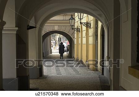 Stock Photo - Person walking through an arch way in Prague. Fotosearch