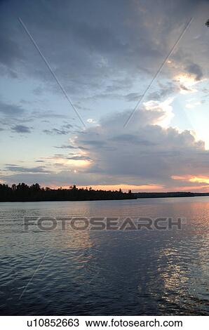 Stock Image - Sunlight through clouds at twilight. Fotosearch