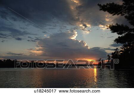 Stock Photo - Sunlight through clouds at twilight. Fotosearch