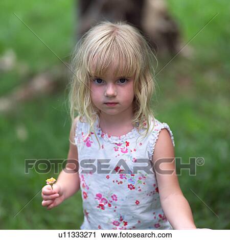 Stock Image - Blond Child Holding Flower. Fotosearch