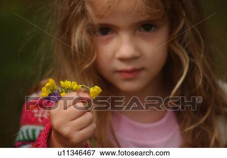 Stock Photo - Young girl holding a bunch of flowers. Fotosearch