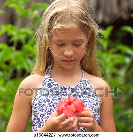 Young girl holding flower View Large Photo Image Stock Photo - Young girl holding flower. Fotosearch