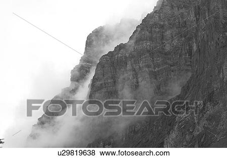 Stock Photo - Fog enveloping a mountain, Rocky Mountains, Canada. Fotosearch