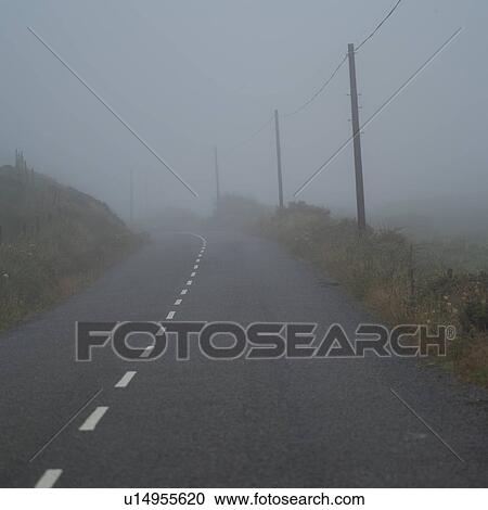Stock Image - Fog on road Irish countryside. Fotosearch
