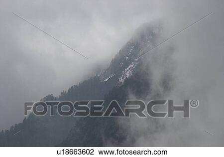 Stock Image - Fog over a mountain range in Slovenia. Fotosearch