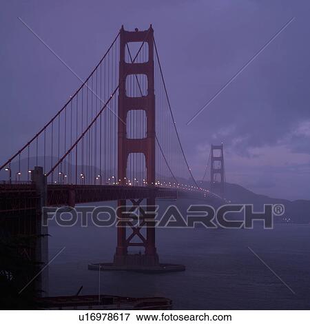 Stock Photo - Golden Gate Bridge in fog at dusk. Fotosearch