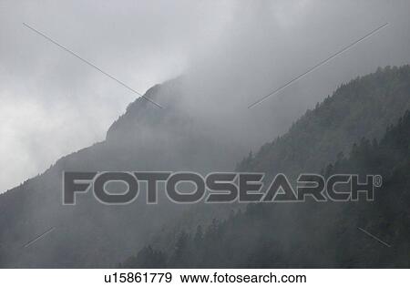 Mountain range surrounded by fog in Slovenia View Large Photo Image Stock Photo - Mountain range surrounded by fog in Slovenia. Fotosearch