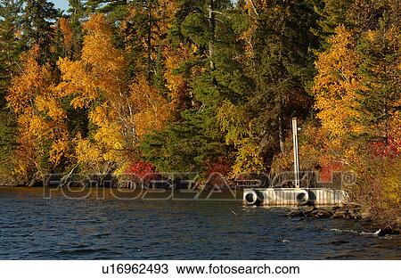 Stock Image - Lake Boat Dock and Autumn Colors. Fotosearch