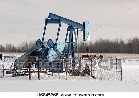 Stock Photo - Oil Well in Field of Snow in Alberta Canada. Fotosearch
