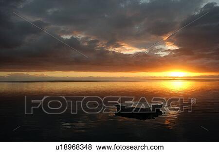 Stock Photo - Panoramic view of the sun setting on the sea, Moorea, Tahiti, French Polynesia, South Pacific. Fotosearch