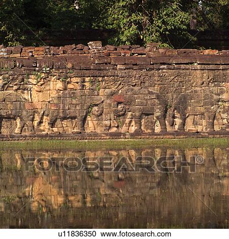 Reflection of a craved wall at the Khmer Kingdom palace ruins View Large Photo Image Stock Image - Reflection of a craved wall at the Khmer Kingdom palace ruins. Fotosearch