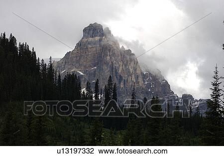 Panoramic view of a mountain peak enveloped in clouds, Rocky Mountains, Canada View Large Photo Image Stock Image - Panoramic view of a mountain peak enveloped in clouds, Rocky Mountains, Canada. Fotosearch