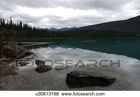 Stock Photo - Shore of a lake, Rocky Mountains, Canada. Fotosearch