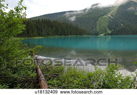 Stock Photo - A lake between mountains, Rocky Mountains, Canada. Fotosearch