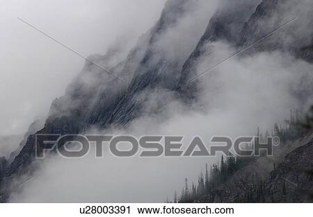 Fog enveloping a mountain, Rocky Mountains, Canada View Large Photo Image Stock Image - Fog enveloping a mountain, Rocky Mountains, Canada. Fotosearch