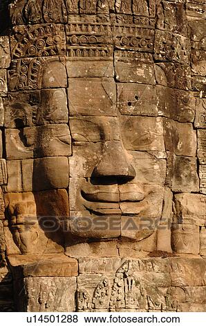 Stone carving of a face on wall at Khmer Kingdom palace ruins View Large Photo Image Stock Photo - Stone carving of a face on wall at Khmer Kingdom palace ruins. Fotosearch