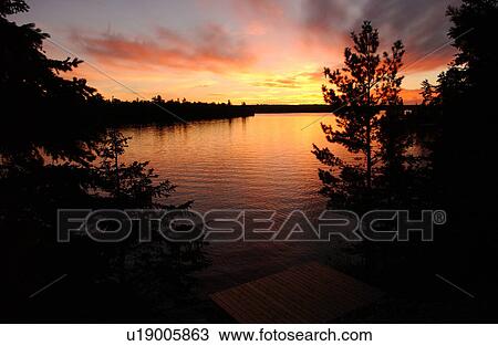 Stock Image - Panoramic view of sunset at Lake of the woods, Ontario, Canada. Fotosearch