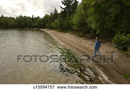 Stock Photo - Person walking on a Lake of the woods, Ontario, Canada. Fotosearch