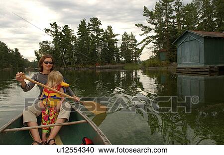 Young woman and her daughter paddling in a canoe on Lake of the woods, Ontario, Canada View Large Photo Image Stock Image - Young woman and her daughter paddling in a canoe on Lake of the woods, Ontario, Canada. Fotosearch