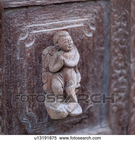 Stock Photography - Statue carved on exterior wall of Buddhist Monastery. Fotosearch