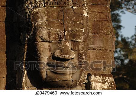 Stone carving of a face on wall at Khmer Kingdom palace ruins View Large Photo Image Stock Image - Stone carving of a face on wall at Khmer Kingdom palace ruins. Fotosearch