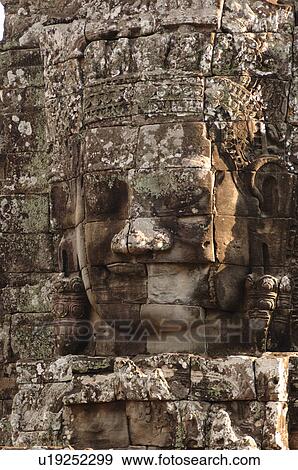 Stone carving of a face on wall at Khmer Kingdom palace ruins View Large Photo Image Stock Photo - Stone carving of a face on wall at Khmer Kingdom palace ruins. Fotosearch