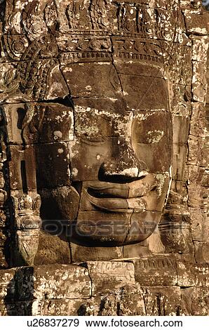 Stone carving of a face on wall at Khmer Kingdom palace ruins View Large Photo Image Stock Photo - Stone carving of a face on wall at Khmer Kingdom palace ruins. Fotosearch
