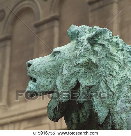 Stock Photography - Stone sculpture of a lion in front of a building. Fotosearch