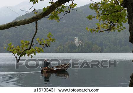 Person in a boat on a lake in Slovenia View Large Photo Image Stock Image - Person in a boat on a lake in Slovenia. Fotosearch