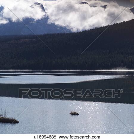 Stock Photography - Silhouette of mountains and sparkling lake. Fotosearch