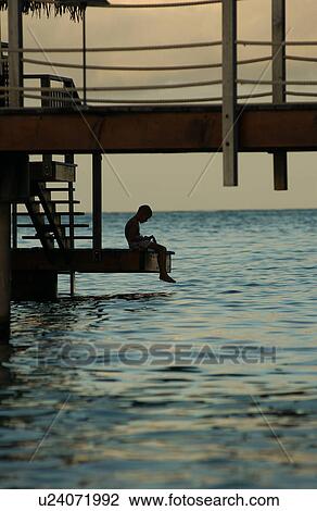A man sitting on steps of a pier, Moorea, Tahiti, French Polynesia, South Pacific View Large Photo Image Stock Image - A man sitting on steps of a pier, Moorea, Tahiti, French Polynesia, South Pacific. Fotosearch
