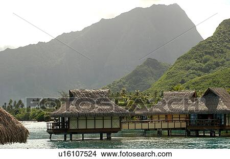 Picture - Thatched roof buildings built on stilts in the sea, Moorea, Tahiti, French Polynesia, South Pacific. Fotosearch