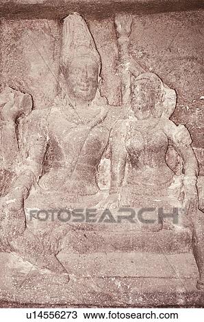 Stock Image - Statues of lord Shiva and goddess Parvati carved in a cave, Ellora, Aurangabad, Maharashtra, India. Fotosearch