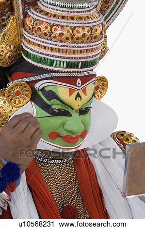 Close-up of a Kathakali dance performer applying make-up on his face View Large Photo Image Stock Image - Close-up of a Kathakali dance performer applying make-up on his face. Fotosearch